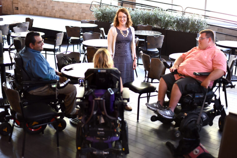 Members of the Accessibility and ADA staff interact with people who use wheelchairs in the Shack of the MU Student Center.