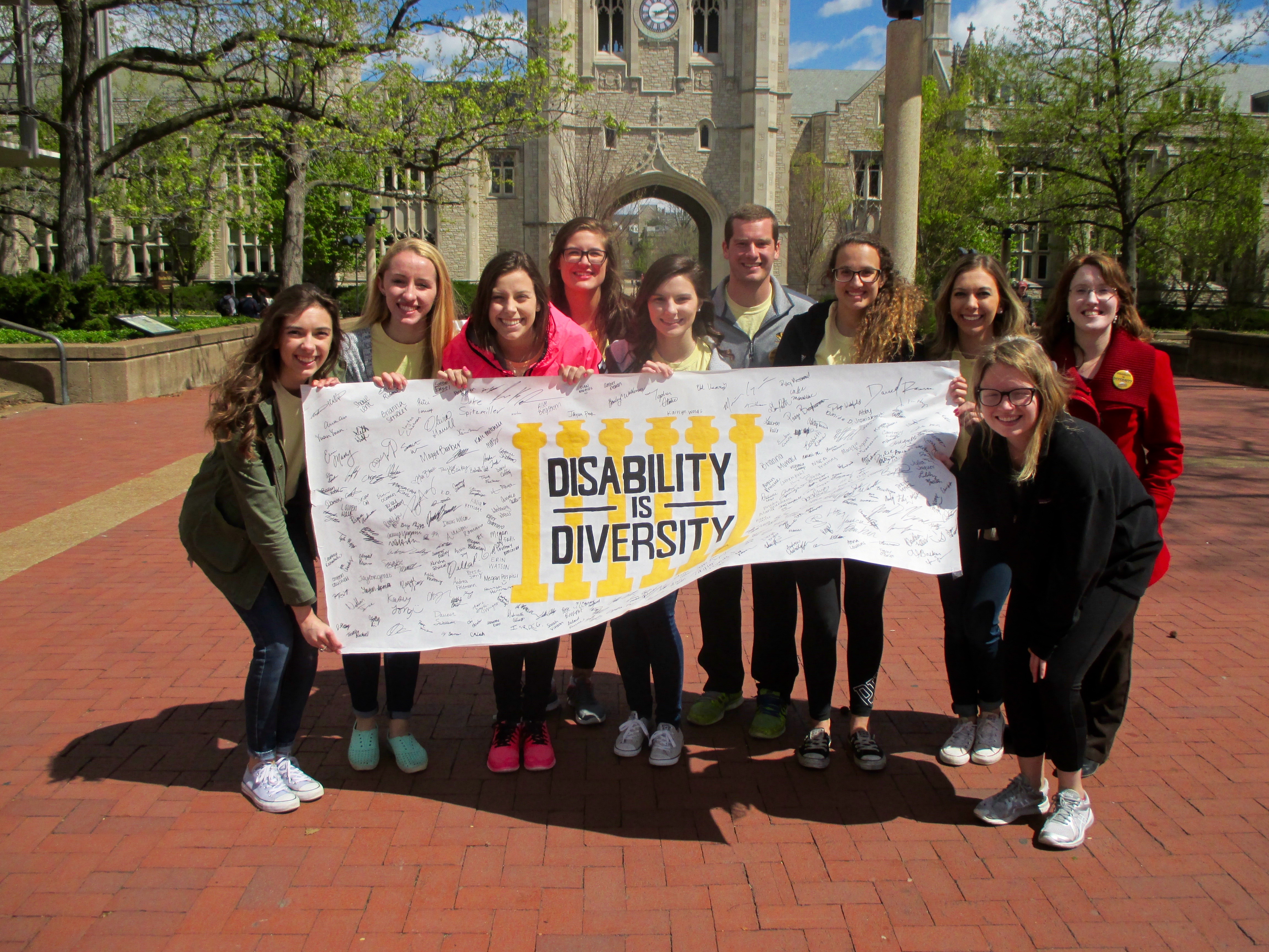 Students pose with the Disability is Diversity banner covered in signatures