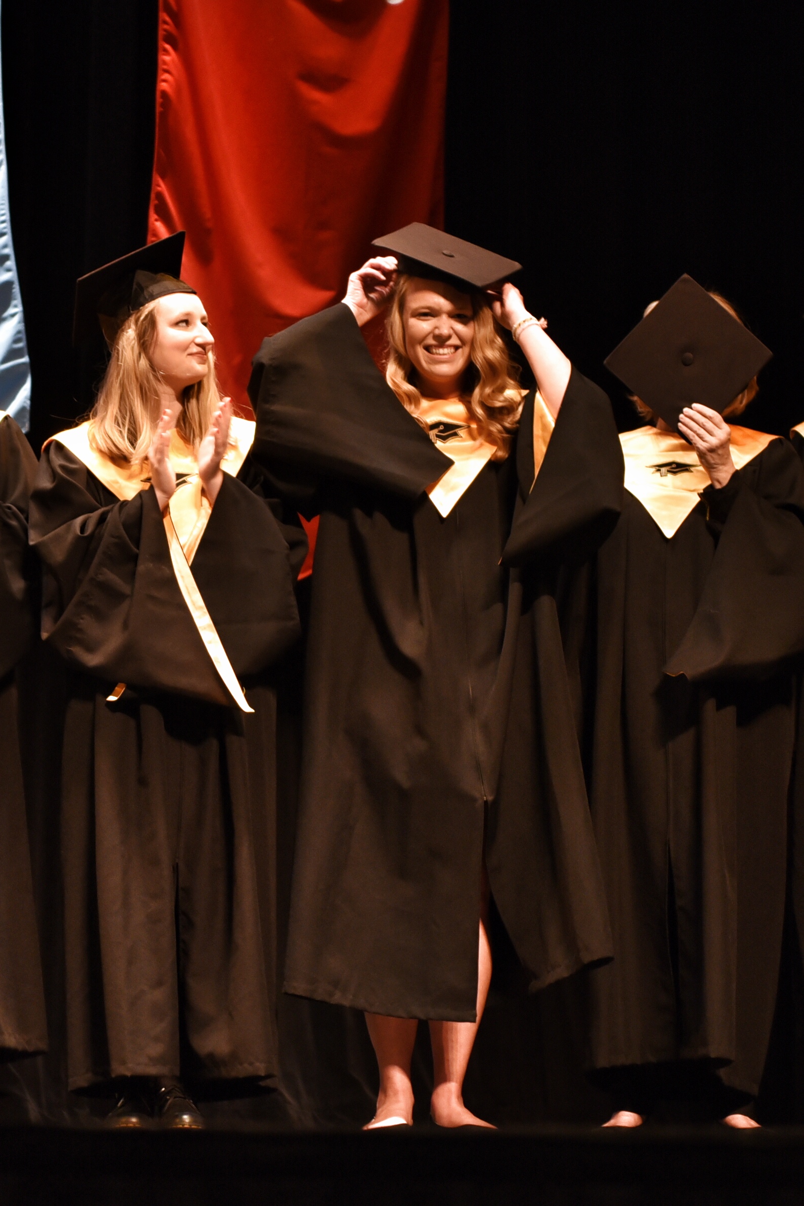 New members of Mortar Board uncover their faces and don mortarboards as they are revealed.