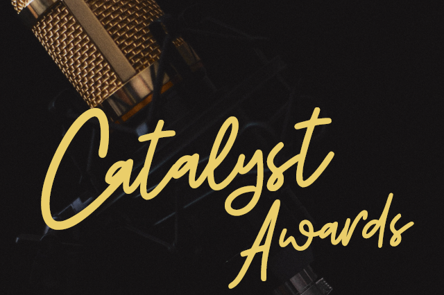 Catalyst Awards in fancier script in front of a microphone