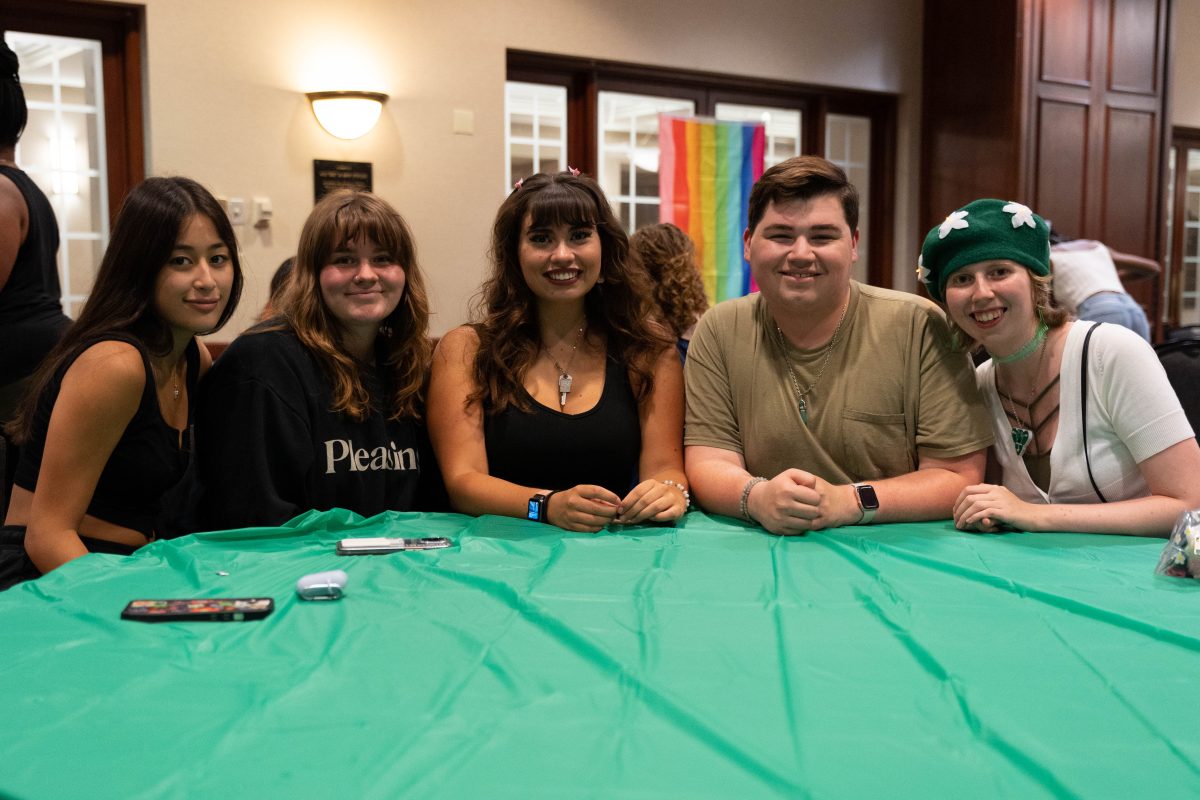 Five students sitting at a table at Fall Queer Fling.