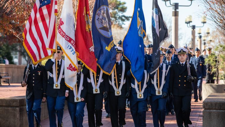 Veterans Day ROTC Color Guard carrying flags representing the US Armed Forces.