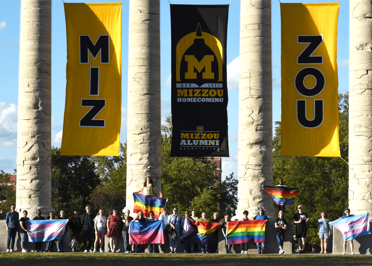 MU students, faculty and staff posing for 2023 Coming Out Day photo at the historic columns.