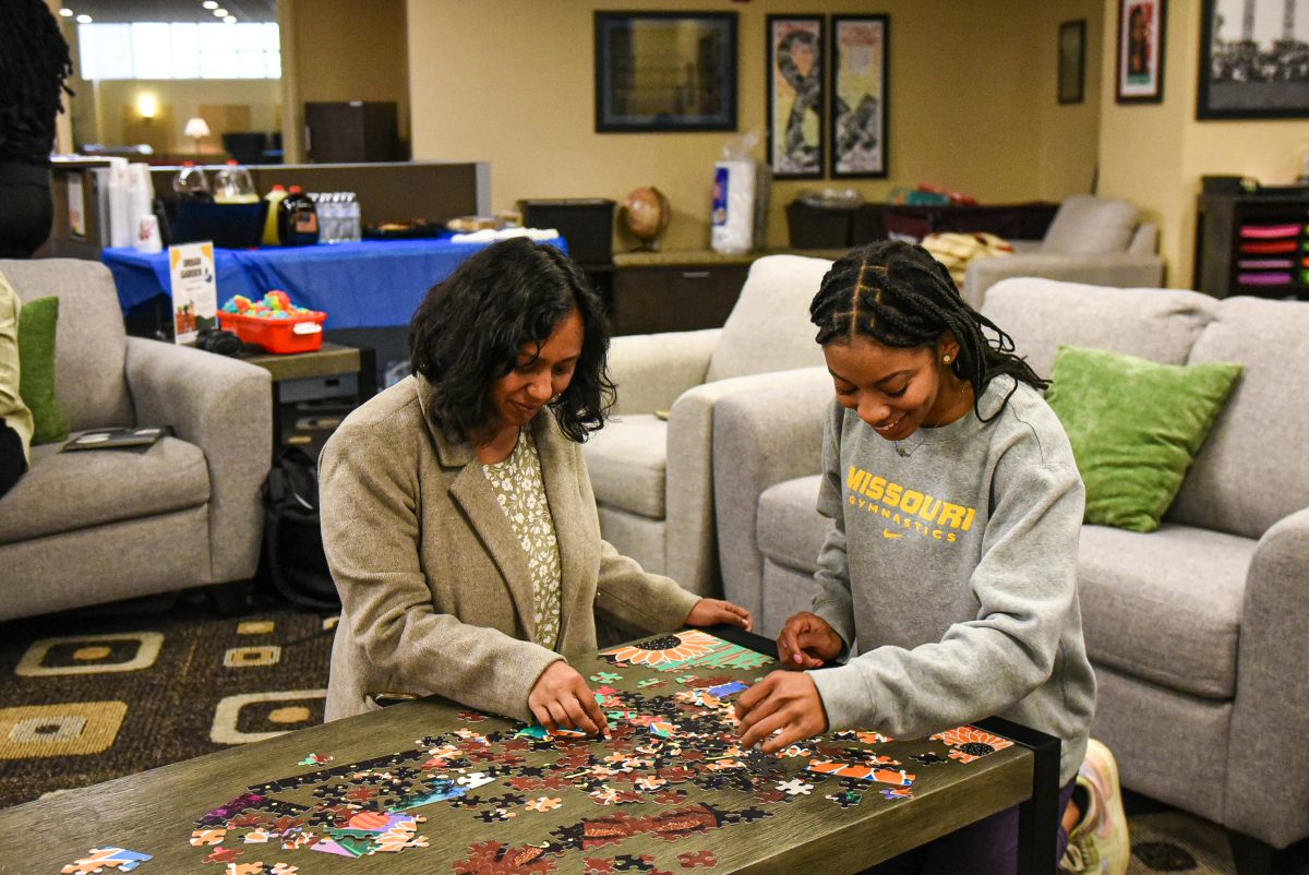 Remya Perinchery, psychologist within the MU Counseling Center and student athlete solve puzzle together. 