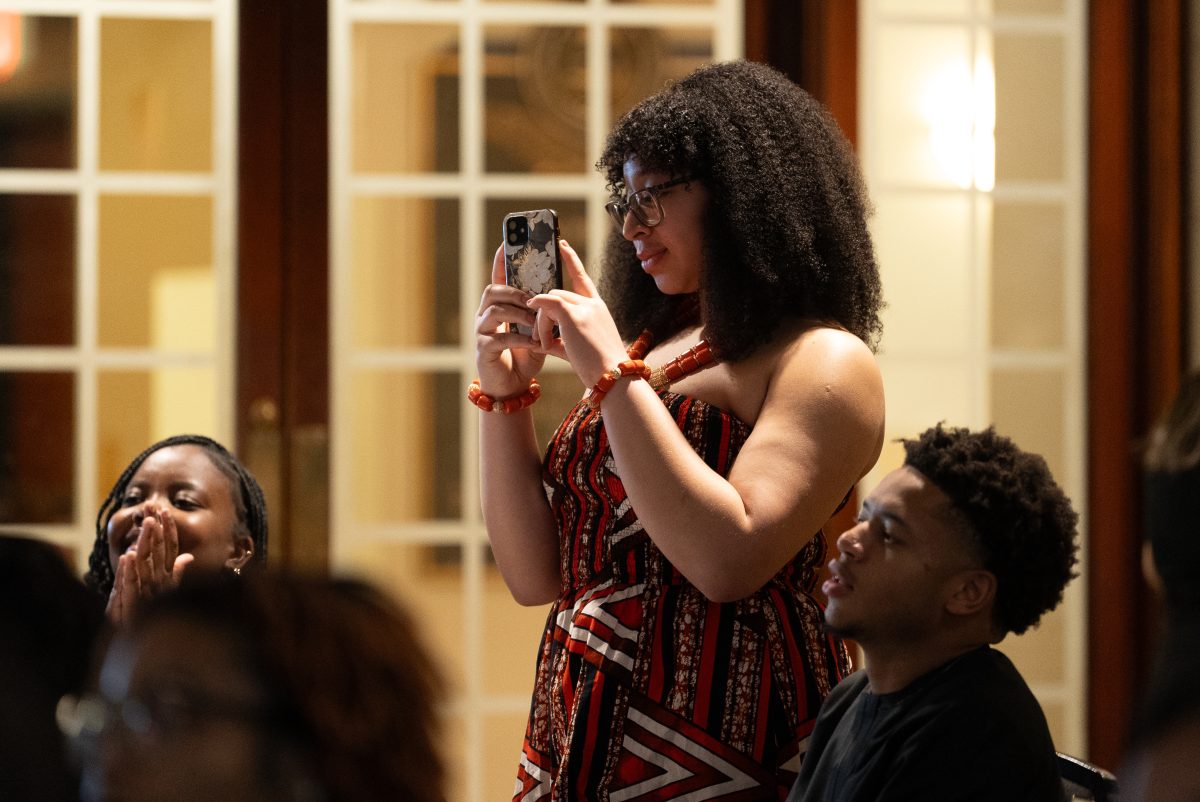 Student attendee stands to take a picture during fashion show. 