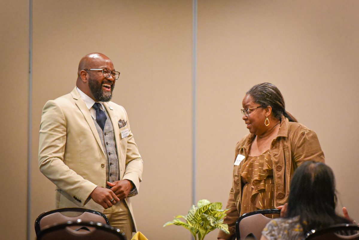 Jerron Johnson, director of Missouri College Advising Corps, laughs in conversation with colleague. 